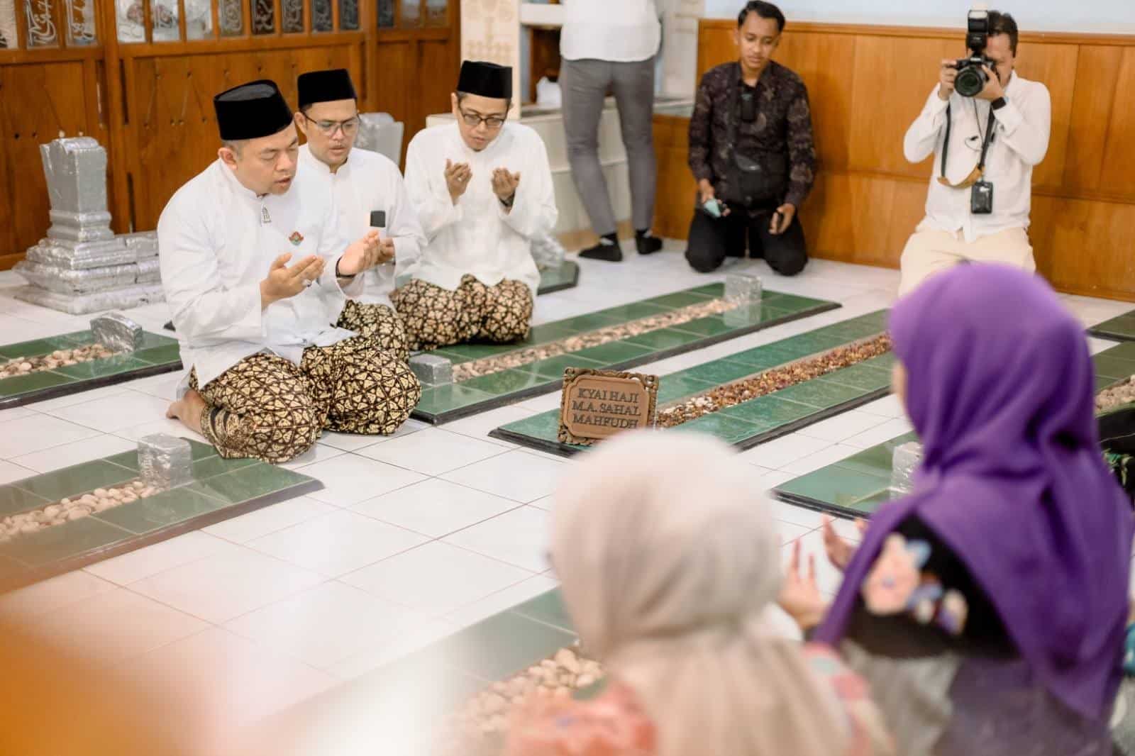 Pengurus Yayasan Makam Mbah Ahmad Mutamakkin, KH Muhammad Faeshol Muzammil mengenakan sarung slobog, sedang memimpin doa dalam ziarah. Dok. Penulis